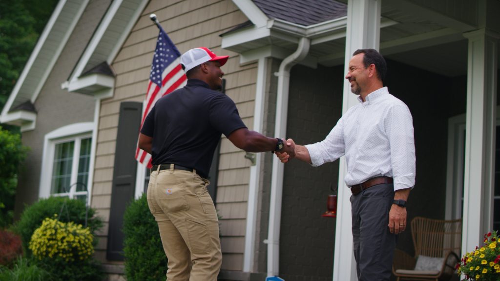 Steve's Service tech shaking hands with a customer outside of a home